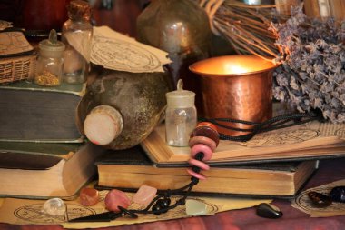 Kara büyü büyü. Wiccan büyüler ve otlar. Hala canlı: Eski yağ lambaları, antika kitap, bakır kase, ilaç şişeleri, lavanta, Pulsatilla pratensis bir antika arka plan üzerinde yanan bir muma gül tomurcukları kurutulmuş. Wicca arka plan.