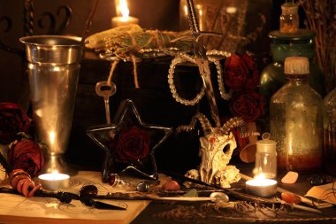 Kara büyü büyü. Wiccan büyüler ve otlar. Hala canlı: Eski yağ lambaları, antika kitap, bakır kase, ilaç şişeleri, lavanta, Pulsatilla pratensis bir antika arka plan üzerinde yanan bir muma gül tomurcukları kurutulmuş. Wicca arka plan.