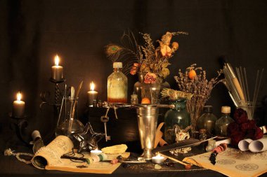 Kara büyü büyü. Wiccan büyüler ve otlar. Hala canlı: Eski yağ lambaları, antika kitap, bakır kase, ilaç şişeleri, lavanta, Pulsatilla pratensis bir antika arka plan üzerinde yanan bir muma gül tomurcukları kurutulmuş. Wicca arka plan.
