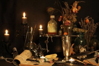 Kara büyü büyü. Wiccan büyüler ve otlar. Hala canlı: Eski yağ lambaları, antika kitap, bakır kase, ilaç şişeleri, lavanta, Pulsatilla pratensis bir antika arka plan üzerinde yanan bir muma gül tomurcukları kurutulmuş. Wicca arka plan.