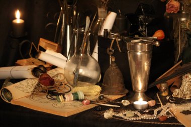 Kara büyü büyü. Wiccan büyüler ve otlar. Hala canlı: Eski yağ lambaları, antika kitap, bakır kase, ilaç şişeleri, lavanta, Pulsatilla pratensis bir antika arka plan üzerinde yanan bir muma gül tomurcukları kurutulmuş. Wicca arka plan.