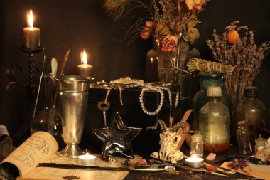 Kara büyü büyü. Wiccan büyüler ve otlar. Hala canlı: Eski yağ lambaları, antika kitap, bakır kase, ilaç şişeleri, lavanta, Pulsatilla pratensis bir antika arka plan üzerinde yanan bir muma gül tomurcukları kurutulmuş. Wicca arka plan.