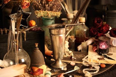 Kara büyü büyü. Wiccan büyüler ve otlar. Hala canlı: Eski yağ lambaları, antika kitap, bakır kase, ilaç şişeleri, lavanta, Pulsatilla pratensis bir antika arka plan üzerinde yanan bir muma gül tomurcukları kurutulmuş. Wicca arka plan.
