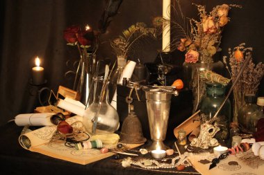 Kara büyü büyü. Wiccan büyüler ve otlar. Hala canlı: Eski yağ lambaları, antika kitap, bakır kase, ilaç şişeleri, lavanta, Pulsatilla pratensis bir antika arka plan üzerinde yanan bir muma gül tomurcukları kurutulmuş. Wicca arka plan.