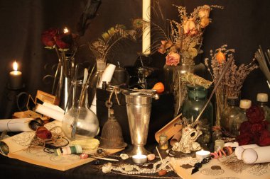 Kara büyü büyü. Wiccan büyüler ve otlar. Hala canlı: Eski yağ lambaları, antika kitap, bakır kase, ilaç şişeleri, lavanta, Pulsatilla pratensis bir antika arka plan üzerinde yanan bir muma gül tomurcukları kurutulmuş. Wicca arka plan.