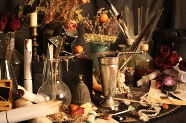 Kara büyü büyü. Wiccan büyüler ve otlar. Hala canlı: Eski yağ lambaları, antika kitap, bakır kase, ilaç şişeleri, lavanta, Pulsatilla pratensis bir antika arka plan üzerinde yanan bir muma gül tomurcukları kurutulmuş. Wicca arka plan.