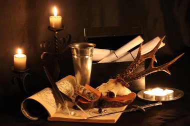 Kara büyü büyü. Wiccan büyüler ve otlar. Hala canlı: Eski yağ lambaları, antika kitap, bakır kase, ilaç şişeleri, lavanta, Pulsatilla pratensis bir antika arka plan üzerinde yanan bir muma gül tomurcukları kurutulmuş. Wicca arka plan.
