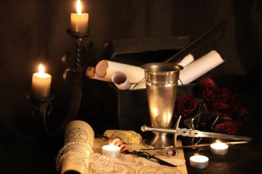 Kara büyü büyü. Wiccan büyüler ve otlar. Hala canlı: Eski yağ lambaları, antika kitap, bakır kase, ilaç şişeleri, lavanta, Pulsatilla pratensis bir antika arka plan üzerinde yanan bir muma gül tomurcukları kurutulmuş. Wicca arka plan.