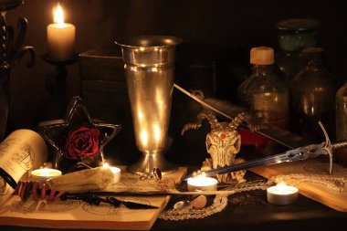 Kara büyü büyü. Wiccan büyüler ve otlar. Hala canlı: Eski yağ lambaları, antika kitap, bakır kase, ilaç şişeleri, lavanta, Pulsatilla pratensis bir antika arka plan üzerinde yanan bir muma gül tomurcukları kurutulmuş. Wicca arka plan.