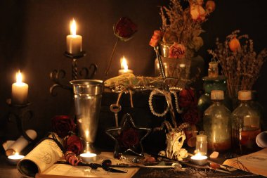 Kara büyü büyü. Wiccan büyüler ve otlar. Hala canlı: Eski yağ lambaları, antika kitap, bakır kase, ilaç şişeleri, lavanta, Pulsatilla pratensis bir antika arka plan üzerinde yanan bir muma gül tomurcukları kurutulmuş. Wicca arka plan.