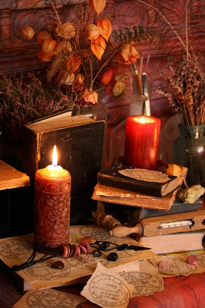 Kara büyü büyü. Wiccan büyüler ve otlar. Hala canlı: Eski yağ lambaları, antika kitap, bakır kase, ilaç şişeleri, lavanta, Pulsatilla pratensis bir antika arka plan üzerinde yanan bir muma gül tomurcukları kurutulmuş. Wicca arka plan.