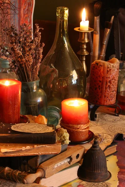 Kara büyü büyü. Wiccan büyüler ve otlar. Hala canlı: Eski yağ lambaları, antika kitap, bakır kase, ilaç şişeleri, lavanta, Pulsatilla pratensis bir antika arka plan üzerinde yanan bir muma gül tomurcukları kurutulmuş. Wicca arka plan.