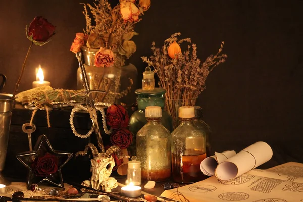 Kara büyü büyü. Wiccan büyüler ve otlar. Hala canlı: Eski yağ lambaları, antika kitap, bakır kase, ilaç şişeleri, lavanta, Pulsatilla pratensis bir antika arka plan üzerinde yanan bir muma gül tomurcukları kurutulmuş. Wicca arka plan.