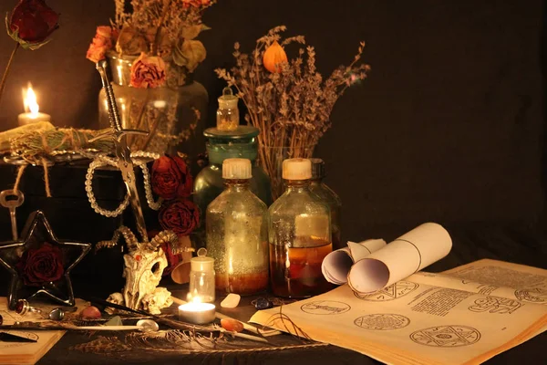 Kara büyü büyü. Wiccan büyüler ve otlar. Hala canlı: Eski yağ lambaları, antika kitap, bakır kase, ilaç şişeleri, lavanta, Pulsatilla pratensis bir antika arka plan üzerinde yanan bir muma gül tomurcukları kurutulmuş. Wicca arka plan.