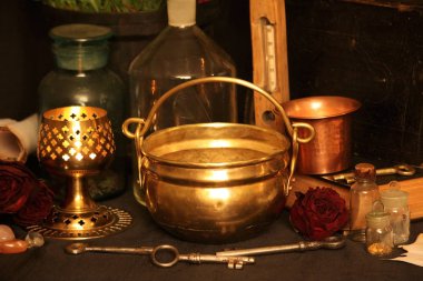 Kara büyü büyü. Wiccan büyüler ve otlar. Hala canlı: Eski yağ lambaları, antika kitap, bakır kase, ilaç şişeleri, lavanta, Pulsatilla pratensis bir antika arka plan üzerinde yanan bir muma gül tomurcukları kurutulmuş. Wicca arka plan.