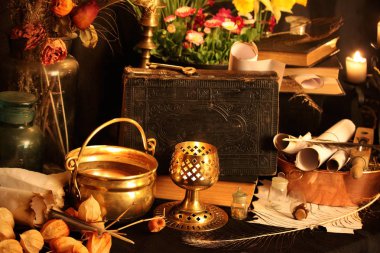 Kara büyü büyü. Wiccan büyüler ve otlar. Hala canlı: Eski yağ lambaları, antika kitap, bakır kase, ilaç şişeleri, lavanta, Pulsatilla pratensis bir antika arka plan üzerinde yanan bir muma gül tomurcukları kurutulmuş. Wicca arka plan.