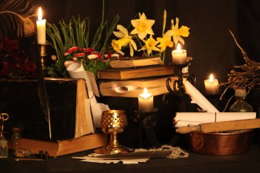 Kara büyü büyü. Wiccan büyüler ve otlar. Hala canlı: Eski yağ lambaları, antika kitap, bakır kase, ilaç şişeleri, lavanta, Pulsatilla pratensis bir antika arka plan üzerinde yanan bir muma gül tomurcukları kurutulmuş. Wicca arka plan.