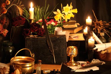 Kara büyü büyü. Wiccan büyüler ve otlar. Hala canlı: Eski yağ lambaları, antika kitap, bakır kase, ilaç şişeleri, lavanta, Pulsatilla pratensis bir antika arka plan üzerinde yanan bir muma gül tomurcukları kurutulmuş. Wicca arka plan.