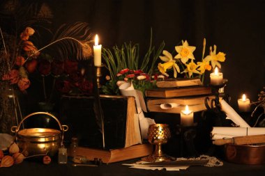 Kara büyü büyü. Wiccan büyüler ve otlar. Hala canlı: Eski yağ lambaları, antika kitap, bakır kase, ilaç şişeleri, lavanta, Pulsatilla pratensis bir antika arka plan üzerinde yanan bir muma gül tomurcukları kurutulmuş. Wicca arka plan.