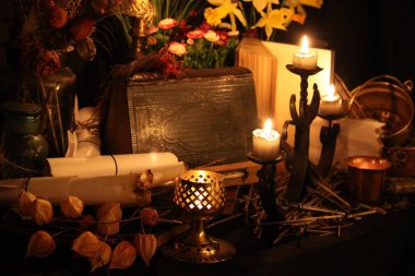 Kara büyü büyü. Wiccan büyüler ve otlar. Hala canlı: Eski yağ lambaları, antika kitap, bakır kase, ilaç şişeleri, lavanta, Pulsatilla pratensis bir antika arka plan üzerinde yanan bir muma gül tomurcukları kurutulmuş. Wicca arka plan.