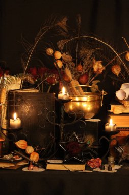 Kara büyü büyü. Wiccan büyüler ve otlar. Hala canlı: Eski yağ lambaları, antika kitap, bakır kase, ilaç şişeleri, lavanta, Pulsatilla pratensis bir antika arka plan üzerinde yanan bir muma gül tomurcukları kurutulmuş. Wicca arka plan.