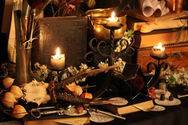 Kara büyü büyü. Wiccan büyüler ve otlar. Hala canlı: Eski yağ lambaları, antika kitap, bakır kase, ilaç şişeleri, lavanta, Pulsatilla pratensis bir antika arka plan üzerinde yanan bir muma gül tomurcukları kurutulmuş. Wicca arka plan.