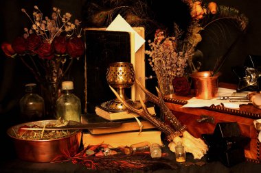 Kara büyü büyü. Wiccan büyüler ve otlar. Hala canlı: Eski yağ lambaları, antika kitap, bakır kase, ilaç şişeleri, lavanta, Pulsatilla pratensis bir antika arka plan üzerinde yanan bir muma gül tomurcukları kurutulmuş. Wicca arka plan.