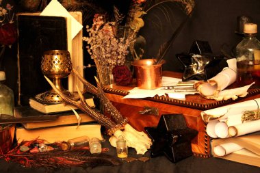 Kara büyü büyü. Wiccan büyüler ve otlar. Hala canlı: Eski yağ lambaları, antika kitap, bakır kase, ilaç şişeleri, lavanta, Pulsatilla pratensis bir antika arka plan üzerinde yanan bir muma gül tomurcukları kurutulmuş. Wicca arka plan.