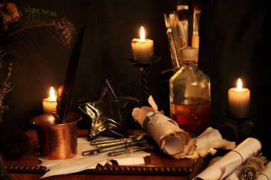 Kara büyü büyü. Wiccan büyüler ve otlar. Hala canlı: Eski yağ lambaları, antika kitap, bakır kase, ilaç şişeleri, lavanta, Pulsatilla pratensis bir antika arka plan üzerinde yanan bir muma gül tomurcukları kurutulmuş. Wicca arka plan.