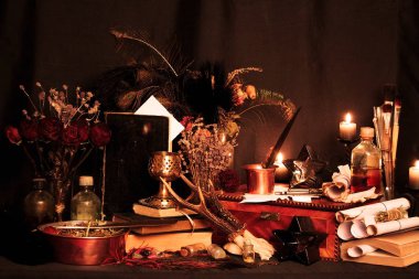 Kara büyü büyü. Wiccan büyüler ve otlar. Hala canlı: Eski yağ lambaları, antika kitap, bakır kase, ilaç şişeleri, lavanta, Pulsatilla pratensis bir antika arka plan üzerinde yanan bir muma gül tomurcukları kurutulmuş. Wicca arka plan.