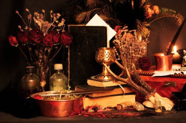 Kara büyü büyü. Wiccan büyüler ve otlar. Hala canlı: Eski yağ lambaları, antika kitap, bakır kase, ilaç şişeleri, lavanta, Pulsatilla pratensis bir antika arka plan üzerinde yanan bir muma gül tomurcukları kurutulmuş. Wicca arka plan.