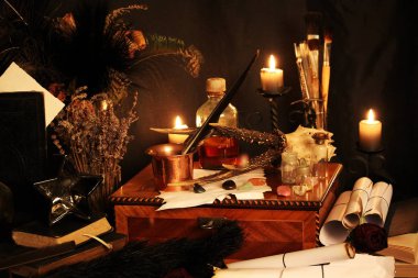 Kara büyü büyü. Wiccan büyüler ve otlar. Hala canlı: Eski yağ lambaları, antika kitap, bakır kase, ilaç şişeleri, lavanta, Pulsatilla pratensis bir antika arka plan üzerinde yanan bir muma gül tomurcukları kurutulmuş. Wicca arka plan.
