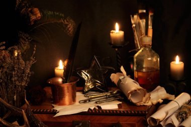Kara büyü büyü. Wiccan büyüler ve otlar. Hala canlı: Eski yağ lambaları, antika kitap, bakır kase, ilaç şişeleri, lavanta, Pulsatilla pratensis bir antika arka plan üzerinde yanan bir muma gül tomurcukları kurutulmuş. Wicca arka plan.