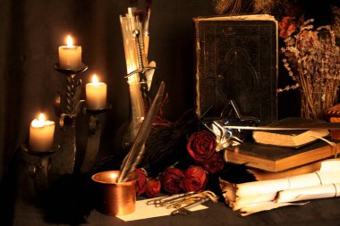 Kara büyü büyü. Wiccan büyüler ve otlar. Hala canlı: Eski yağ lambaları, antika kitap, bakır kase, ilaç şişeleri, lavanta, Pulsatilla pratensis bir antika arka plan üzerinde yanan bir muma gül tomurcukları kurutulmuş. Wicca arka plan.