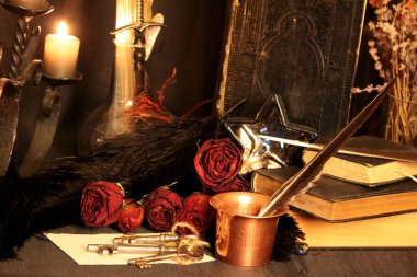 Kara büyü büyü. Wiccan büyüler ve otlar. Hala canlı: Eski yağ lambaları, antika kitap, bakır kase, ilaç şişeleri, lavanta, Pulsatilla pratensis bir antika arka plan üzerinde yanan bir muma gül tomurcukları kurutulmuş. Wicca arka plan.