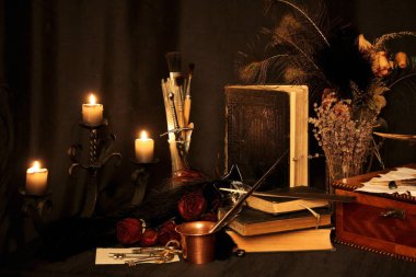 Kara büyü büyü. Wiccan büyüler ve otlar. Hala canlı: Eski yağ lambaları, antika kitap, bakır kase, ilaç şişeleri, lavanta, Pulsatilla pratensis bir antika arka plan üzerinde yanan bir muma gül tomurcukları kurutulmuş. Wicca arka plan.