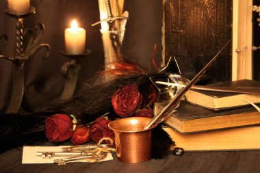 Kara büyü büyü. Wiccan büyüler ve otlar. Hala canlı: Eski yağ lambaları, antika kitap, bakır kase, ilaç şişeleri, lavanta, Pulsatilla pratensis bir antika arka plan üzerinde yanan bir muma gül tomurcukları kurutulmuş. Wicca arka plan.