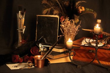 Kara büyü büyü. Wiccan büyüler ve otlar. Hala canlı: Eski yağ lambaları, antika kitap, bakır kase, ilaç şişeleri, lavanta, Pulsatilla pratensis bir antika arka plan üzerinde yanan bir muma gül tomurcukları kurutulmuş. Wicca arka plan.