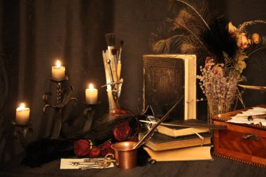 Kara büyü büyü. Wiccan büyüler ve otlar. Hala canlı: Eski yağ lambaları, antika kitap, bakır kase, ilaç şişeleri, lavanta, Pulsatilla pratensis bir antika arka plan üzerinde yanan bir muma gül tomurcukları kurutulmuş. Wicca arka plan.