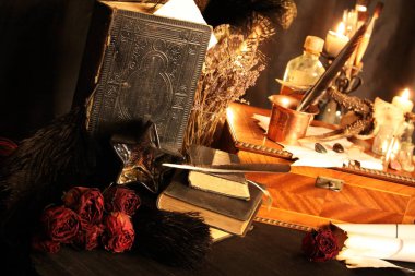 Kara büyü büyü. Wiccan büyüler ve otlar. Hala canlı: Eski yağ lambaları, antika kitap, bakır kase, ilaç şişeleri, lavanta, Pulsatilla pratensis bir antika arka plan üzerinde yanan bir muma gül tomurcukları kurutulmuş. Wicca arka plan.