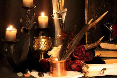 Kara büyü büyü. Wiccan büyüler ve otlar. Hala canlı: Eski yağ lambaları, antika kitap, bakır kase, ilaç şişeleri, lavanta, Pulsatilla pratensis bir antika arka plan üzerinde yanan bir muma gül tomurcukları kurutulmuş. Wicca arka plan.