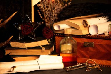 Kara büyü büyü. Wiccan büyüler ve otlar. Hala canlı: Eski yağ lambaları, antika kitap, bakır kase, ilaç şişeleri, lavanta, Pulsatilla pratensis bir antika arka plan üzerinde yanan bir muma gül tomurcukları kurutulmuş. Wicca arka plan.