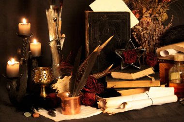 Kara büyü büyü. Wiccan büyüler ve otlar. Hala canlı: Eski yağ lambaları, antika kitap, bakır kase, ilaç şişeleri, lavanta, Pulsatilla pratensis bir antika arka plan üzerinde yanan bir muma gül tomurcukları kurutulmuş. Wicca arka plan.