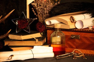 Kara büyü büyü. Wiccan büyüler ve otlar. Hala canlı: Eski yağ lambaları, antika kitap, bakır kase, ilaç şişeleri, lavanta, Pulsatilla pratensis bir antika arka plan üzerinde yanan bir muma gül tomurcukları kurutulmuş. Wicca arka plan.