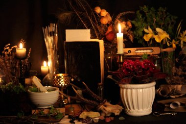 Kara büyü büyü. Wiccan büyüler ve otlar. Hala canlı: Eski yağ lambaları, antika kitap, bakır kase, ilaç şişeleri, lavanta, Pulsatilla pratensis bir antika arka plan üzerinde yanan bir muma gül tomurcukları kurutulmuş. Wicca arka plan.
