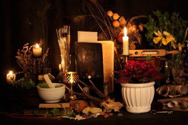 Kara büyü büyü. Wiccan büyüler ve otlar. Hala canlı: Eski yağ lambaları, antika kitap, bakır kase, ilaç şişeleri, lavanta, Pulsatilla pratensis bir antika arka plan üzerinde yanan bir muma gül tomurcukları kurutulmuş. Wicca arka plan.