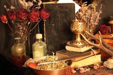 Kara büyü büyü. Wiccan büyüler ve otlar. Hala canlı: Eski yağ lambaları, antika kitap, bakır kase, ilaç şişeleri, lavanta, Pulsatilla pratensis bir antika arka plan üzerinde yanan bir muma gül tomurcukları kurutulmuş. Wicca arka plan.