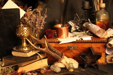 Kara büyü büyü. Wiccan büyüler ve otlar. Hala canlı: Eski yağ lambaları, antika kitap, bakır kase, ilaç şişeleri, lavanta, Pulsatilla pratensis bir antika arka plan üzerinde yanan bir muma gül tomurcukları kurutulmuş. Wicca arka plan.