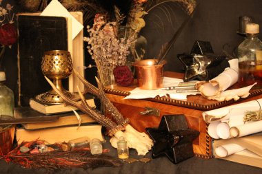Kara büyü büyü. Wiccan büyüler ve otlar. Hala canlı: Eski yağ lambaları, antika kitap, bakır kase, ilaç şişeleri, lavanta, Pulsatilla pratensis bir antika arka plan üzerinde yanan bir muma gül tomurcukları kurutulmuş. Wicca arka plan.