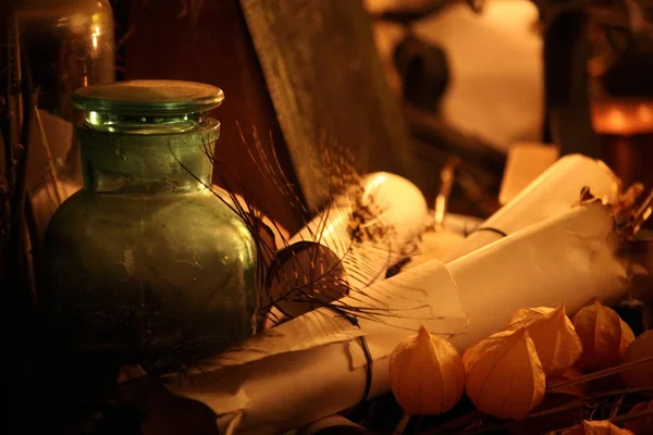 Black Magic Spells. Wiccan spells and herbs. Still Live: Old oil lamps, antique books, dried rose buds, a burning candle in a copper bowl, medicine bottles, lavender, Pulsatilla pratensis on an antique background. Wicca background.